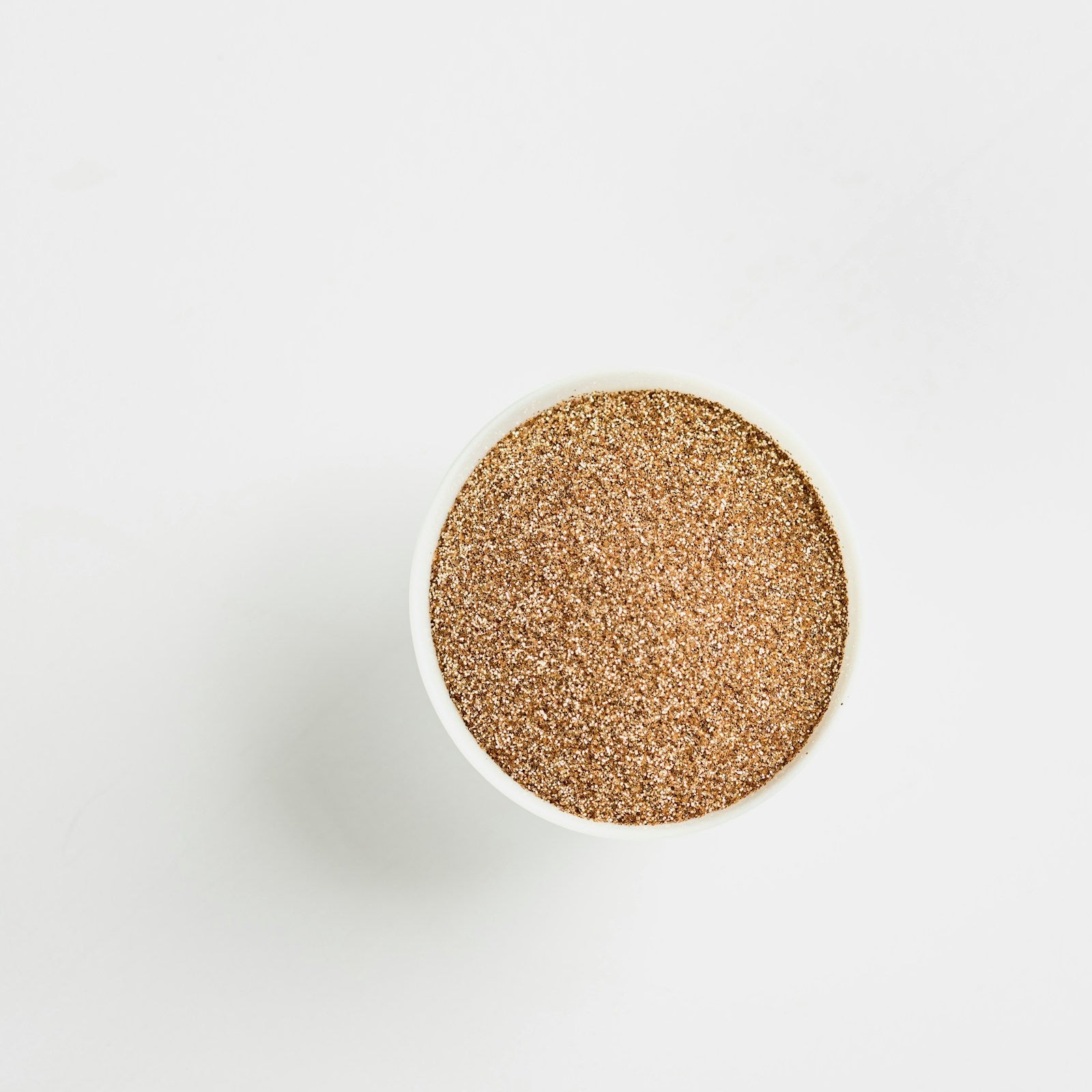 Rhassoul clay powder in a white ceramic bowl on a white background