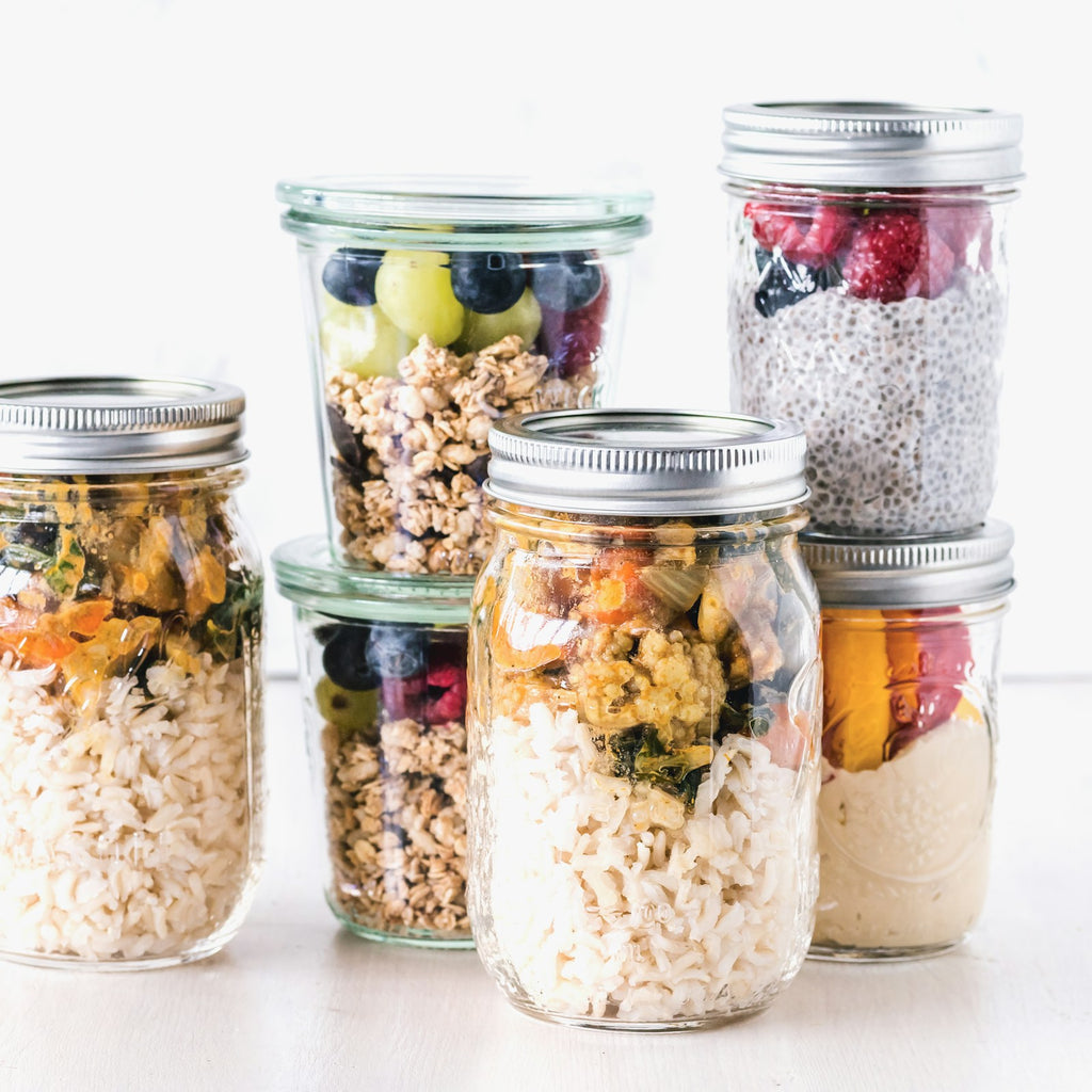 Set of six glass mason jars with lids on a white background