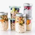 Set of six glass mason jars with lids on a white background