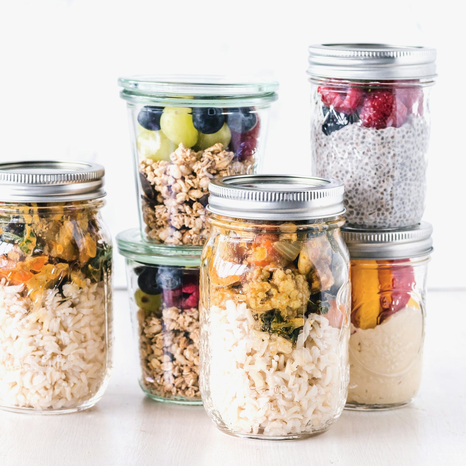 Set of six glass mason jars with lids on a white background