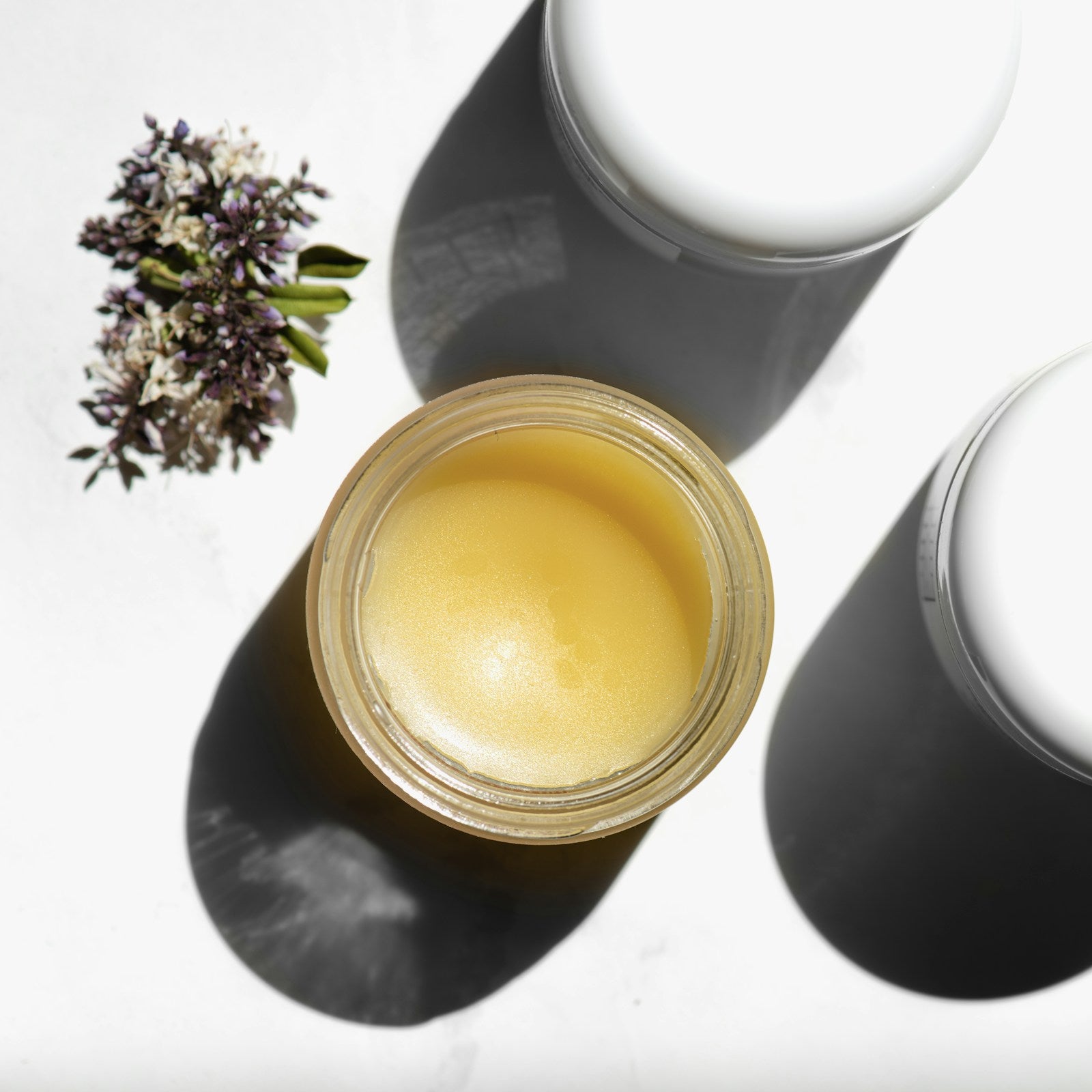 Open jar of shea butter balm on a white background