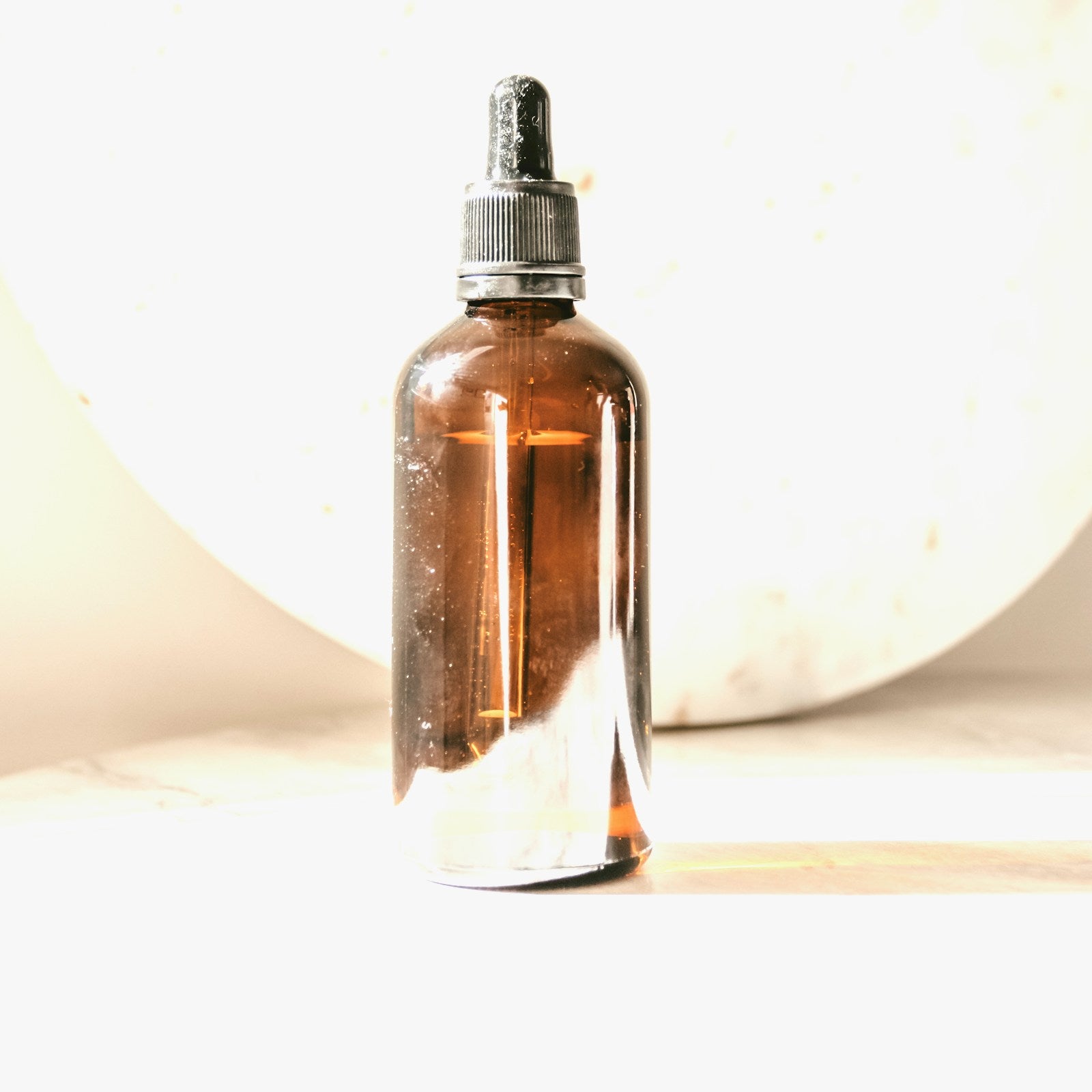 Amber glass bottle of witch hazel toner on a white background