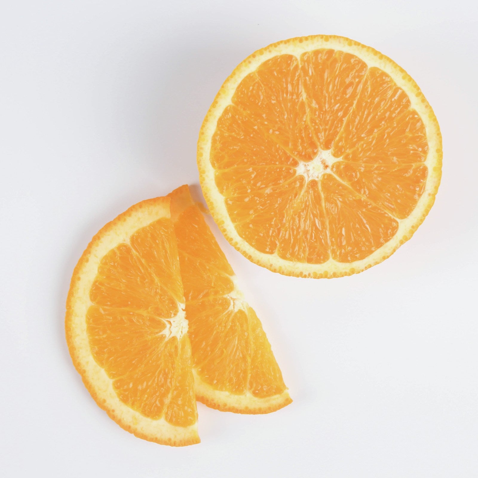 Fresh orange slices on a white studio background