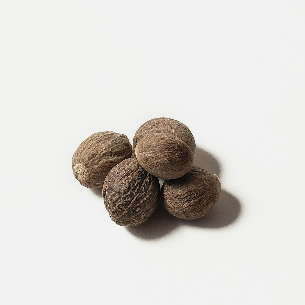 Whole organic nutmeg seeds on a white background