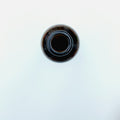 Dark glass bottle of black seed oil on a white background