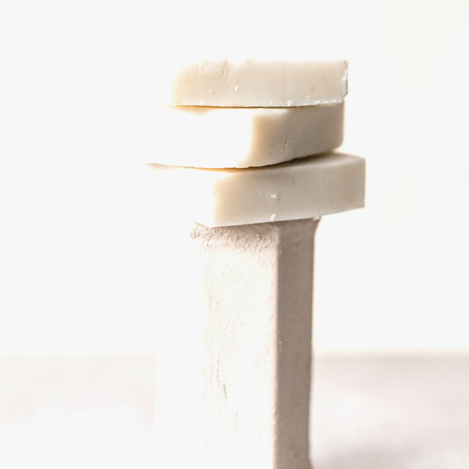Stacked natural olive oil soap bars on a white background