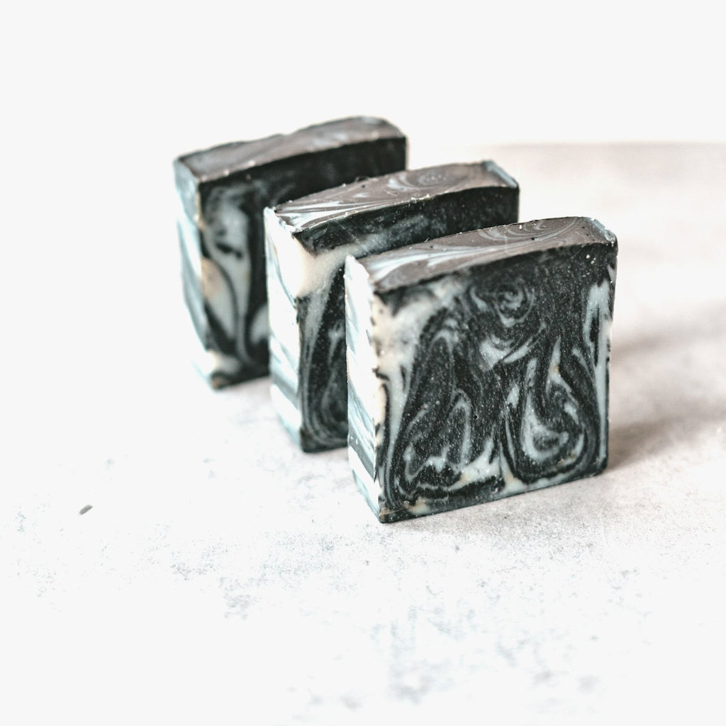 Activated charcoal soap bars with marbled black and white swirl on a white background