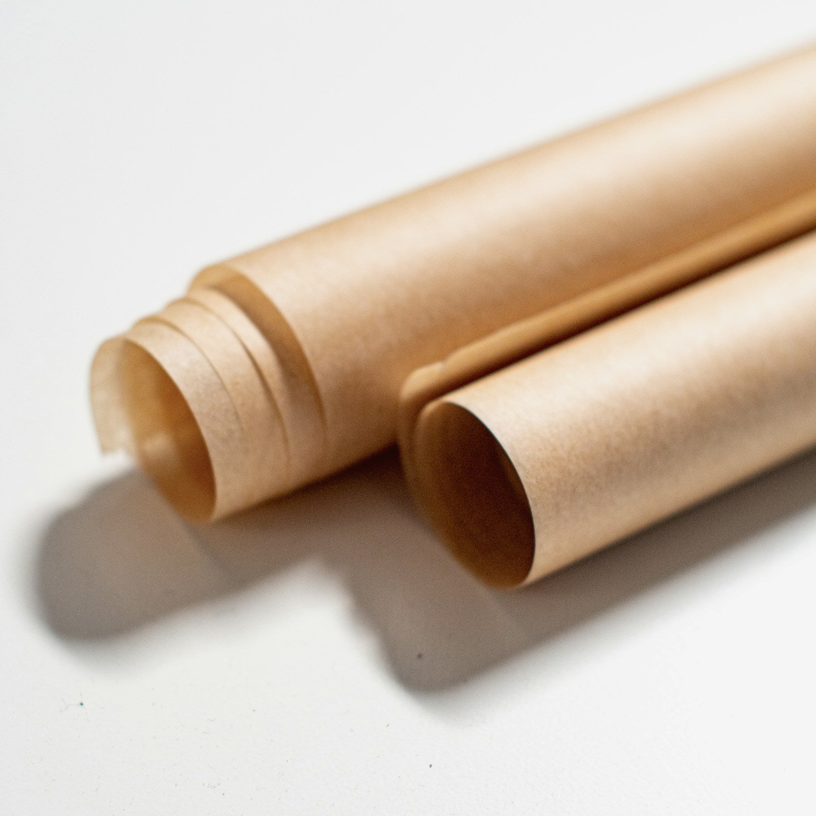 Rolls of unbleached baking paper on a white background