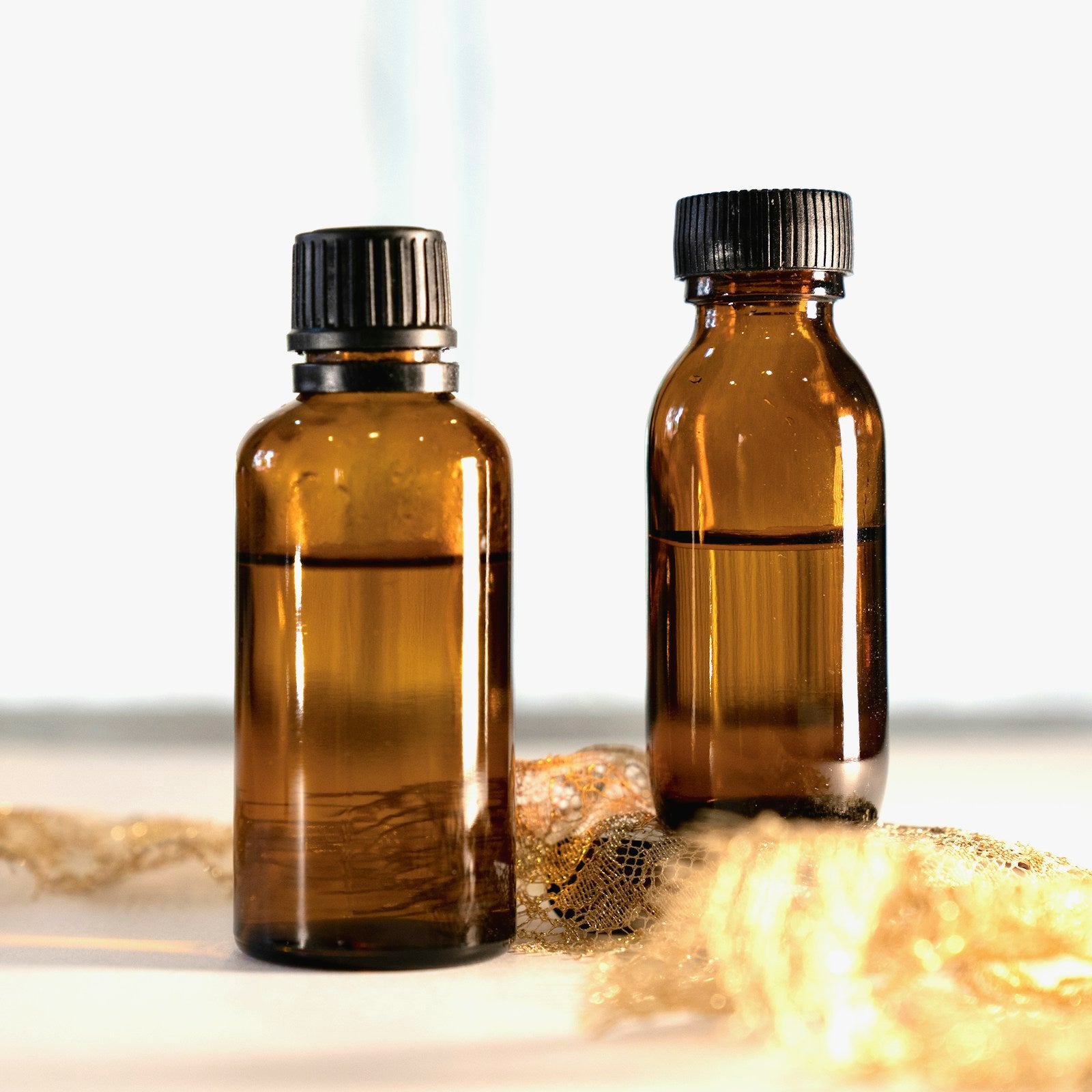 Amber glass neem oil bottles on a light studio background