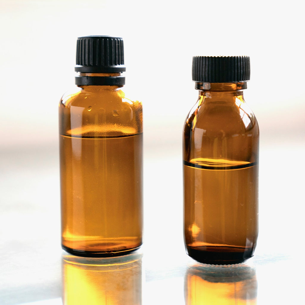 Amber glass neem oil bottles on a light studio background