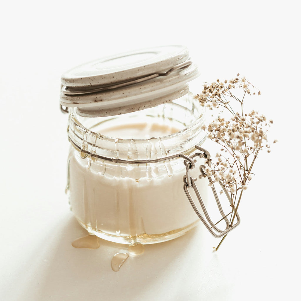Jar of unrefined ivory butter on a white background
