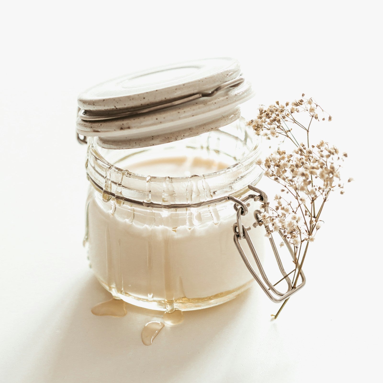 Jar of unrefined ivory butter on a white background