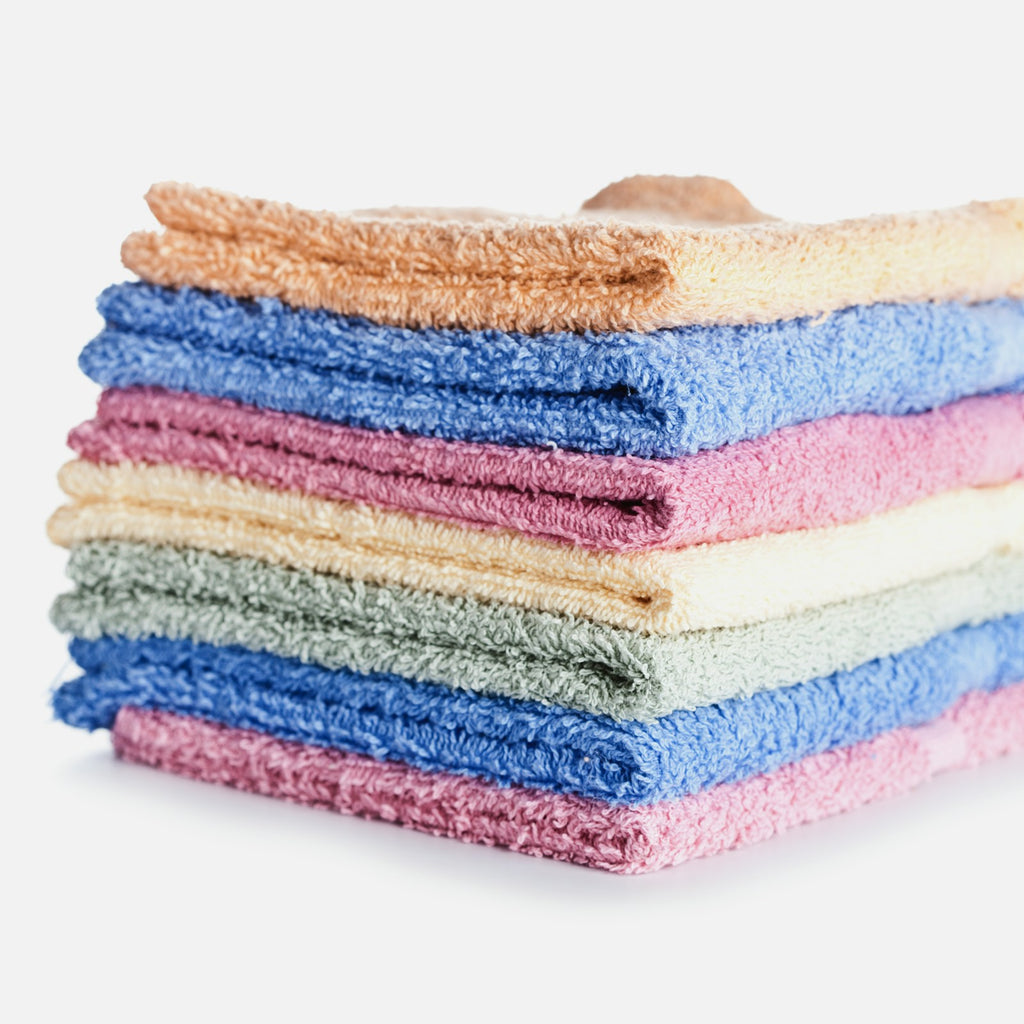 Stack of folded reusable kitchen dishcloths on a white background