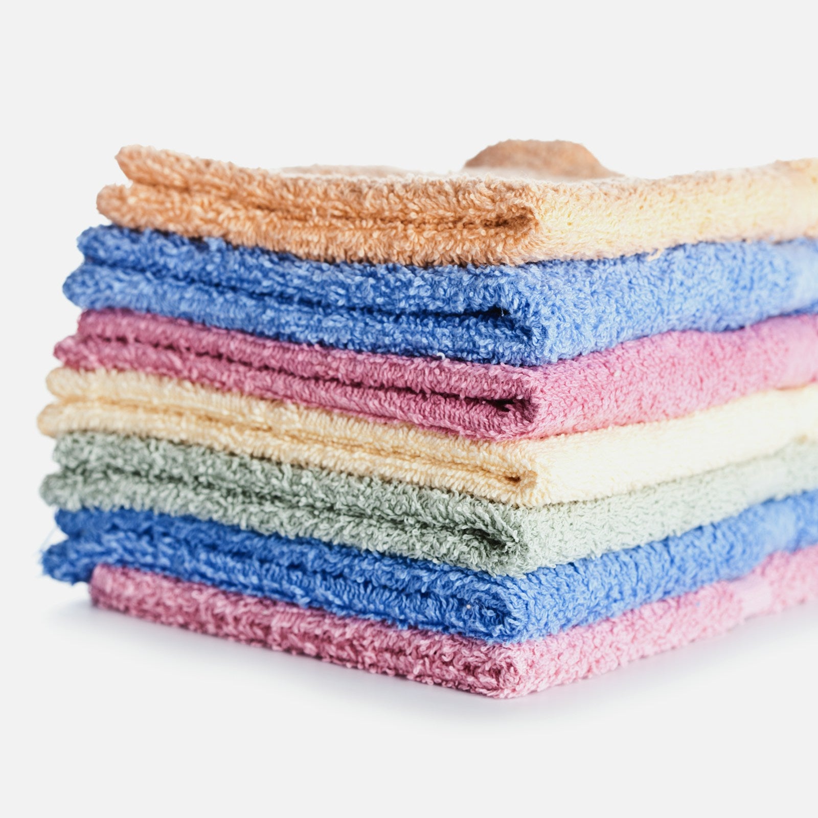 Stack of folded reusable kitchen dishcloths on a white background